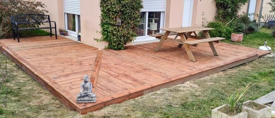 Chantier de pose de terrasse en bois en novembre, lames gelées, conditions hivernales en Normandie
