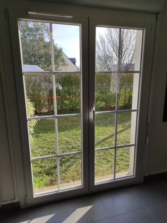 Porte-fenêtre PVC 2 vantaux petits bois vue intérieure Calvados
