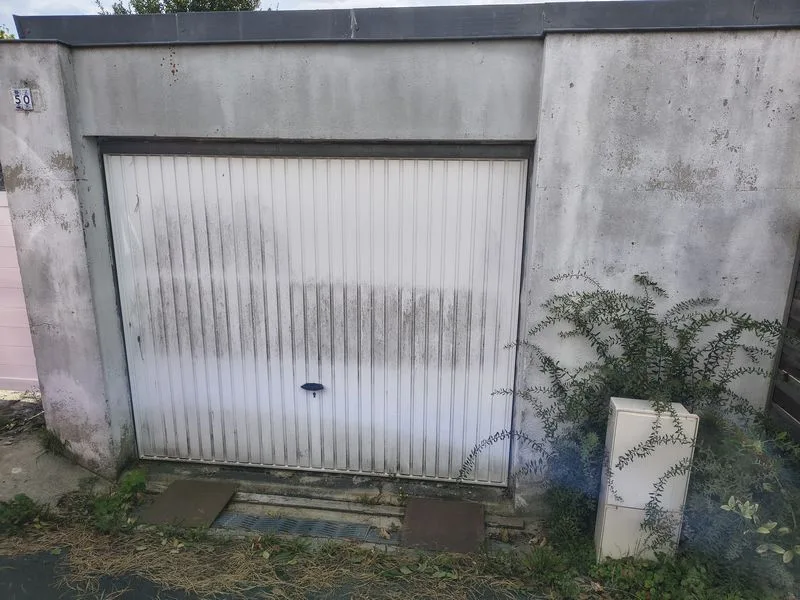 Ancienne porte de garage en tôle débordante avant remplacement à Hérouville-Saint-Clair – Photo LC Rénover Ancienne porte de garage en tôle débordante avant remplacement à Hérouville-Saint-Clair