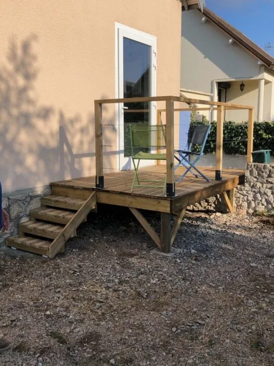 Petit balcon sur pilotis garde corps bois et petit escalier